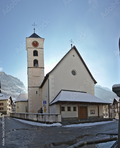 Church with golden red clock in vals switzerland. Winter landscape in the background