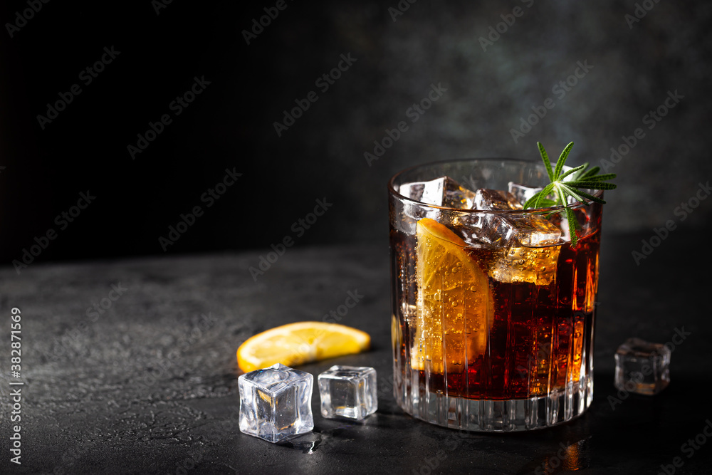 Fresh made Cuba Libre cocktail with brown rum, cola and lemon on wooden background - obrazy, fototapety, plakaty 