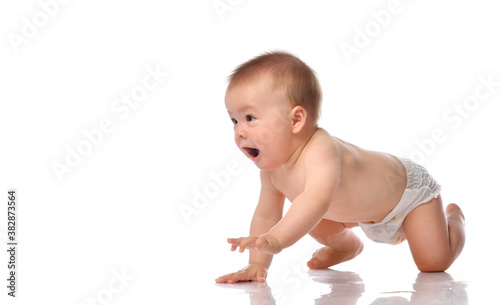 little baby in a diaper crawls on the floor and looks at the corner  joyfully crawls there isolated on a white background.
