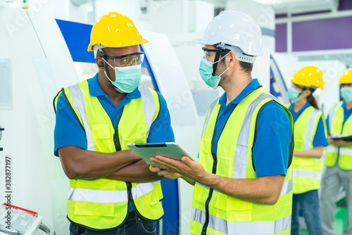 Professional engineering walking discuss inspecting with engineer team in clean room machinery factory area. Manager hand use tablet listenreport paper for internal audit.  New normal factory concept © whyframeshot