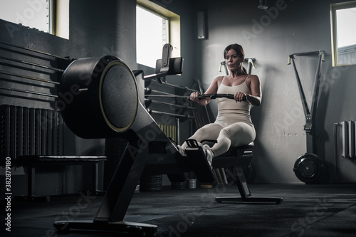 Strong Woman Finishes Training on Rowing Machine .