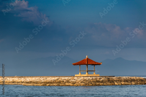 A single hut in the middle of the sea surrounded by blue water and evening sky with tranquil view during vacation in Bali © Souvik