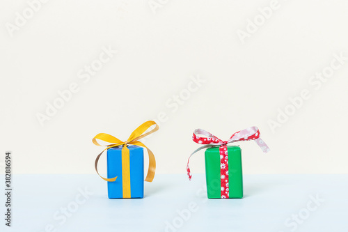 Two colorful gift boxes on a pastel background