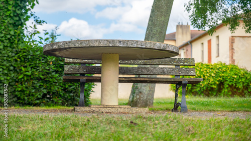 Ground view of a round stone table and bench, outdoors 
