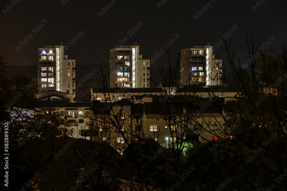 Enkoping, Sweden Three lit up apartment towers in the downtown at night.