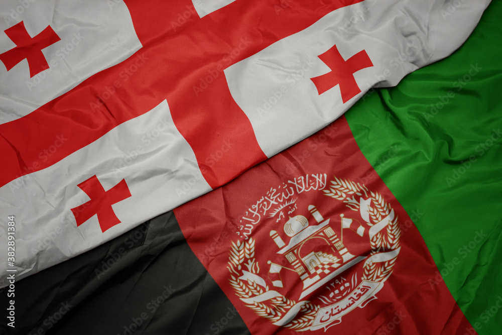 Fototapeta premium waving colorful flag of afghanistan and national flag of georgia. macro