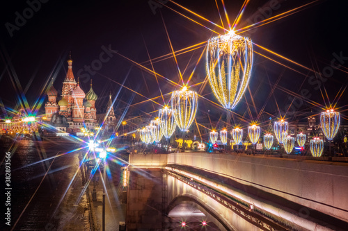 Moscow. Russia. Festive lights of Moscow. Lights on the bridge are decorated with garlands. Glowing garlands on the background of St. Basil's Cathedral. Christmas in Moscow. New year's eve.