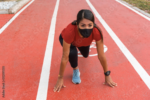 Female runner preparing for the race. Women in good physical shape, training and exercising outdoors in summer as part of a healthy lifestyle.
