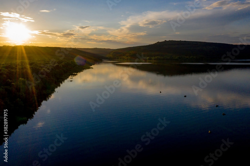 aerial view of fisherman at the boat on golden sunset river. silhouette of fishermen with his boat, Fisherman life style © volody10