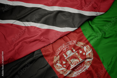 waving colorful flag of afghanistan and national flag of trinidad and tobago. macro