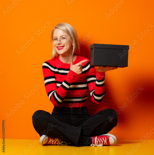 Style hipster girl with gfit box sitting on a floor photo