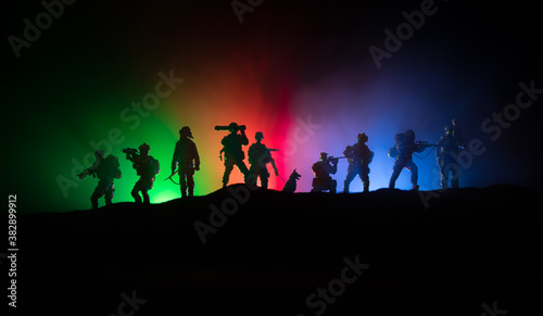 Azeri army concept. Silhouette of armed soldiers against Azerbaijani flag. Creative artwork decoration. Military silhouettes fighting scene dark toned foggy background.