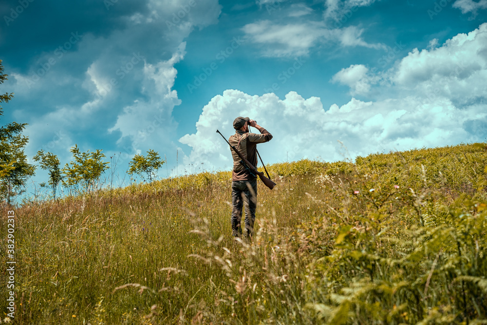 Young hunter on a hill checking his surrounding for prey Young hunter on a hill checking his surrounding for prey