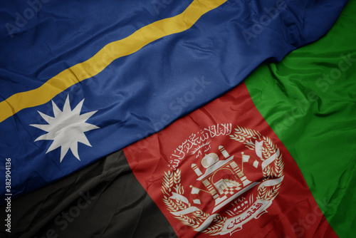 waving colorful flag of afghanistan and national flag of Nauru . macro