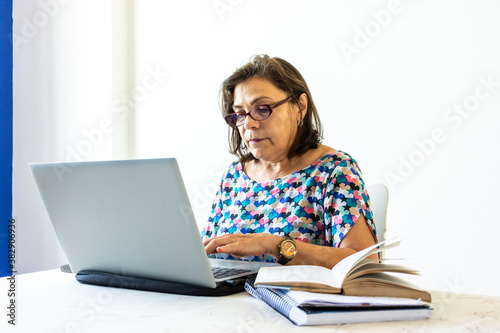 Mulher meia idade concentrada virtualmente no trabalho computador 