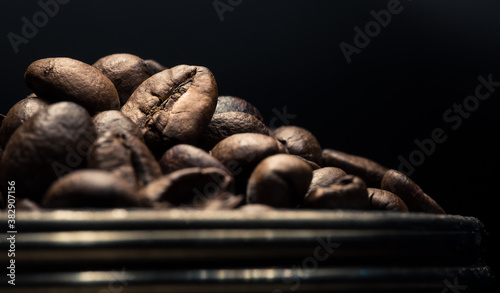 Pile of roasted coffee beans close up. Preparation of aromatic coffee. Coffee is the world's most popular stimulating drink.