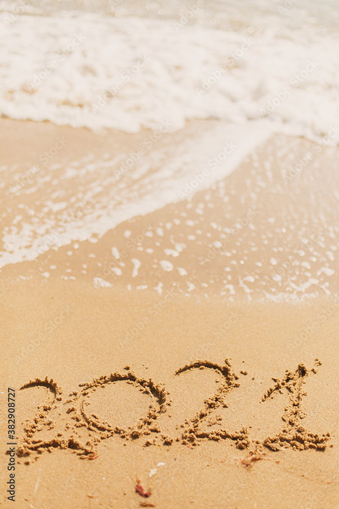2021 handwritten sign on sandy beach with waves and white foam. Happy New year 2021 2021 handwritten sign on sandy beach with waves and white foam. Happy New year 2021