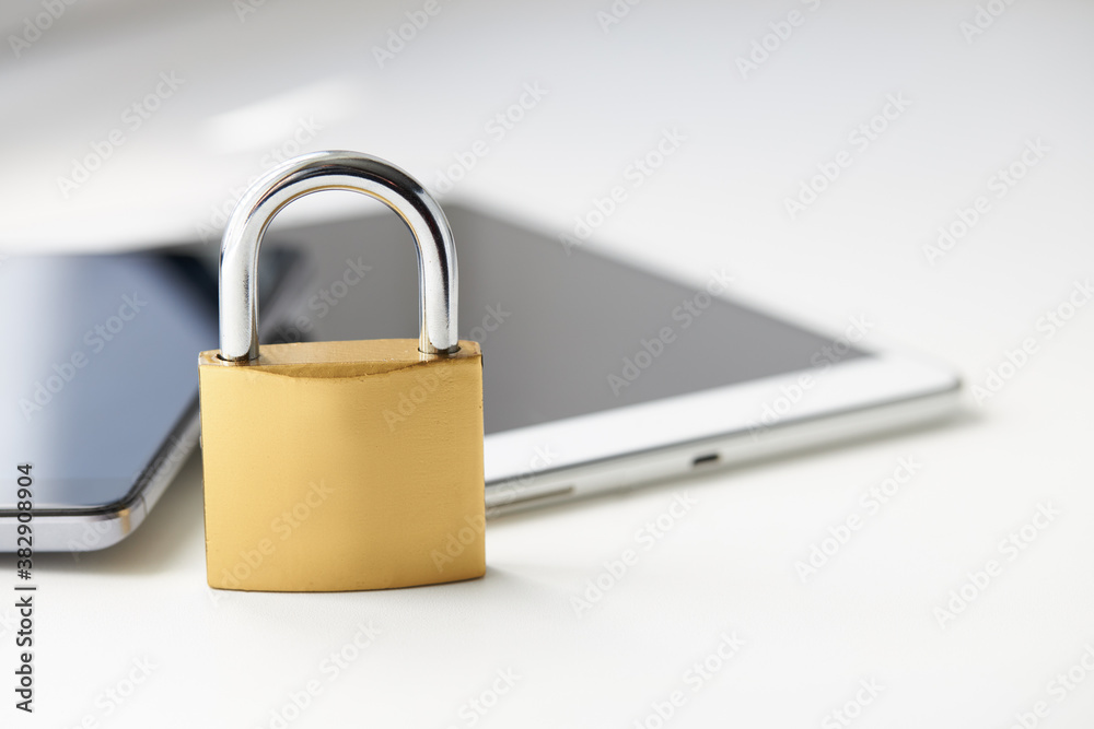 Fototapeta premium tablet pc and smartphone with padlock over white background. digital data security concept. virus protection software concept