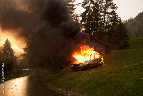 Brennendes Auto nach einem Verkehrsunfall auf der Strasse.  photo