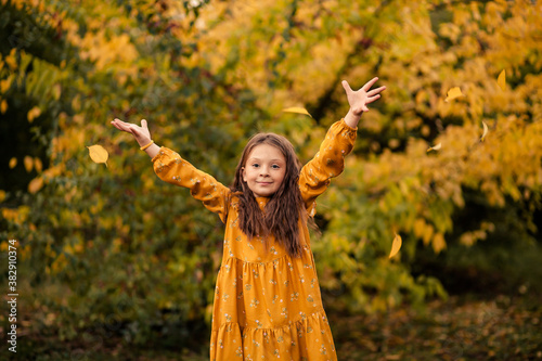 Happy cute girl 7-8 years old in autumn park