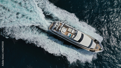 Aerial drone photo of small luxury yacht with wooden deck cruising open ocean deep blue sea © aerial-drone