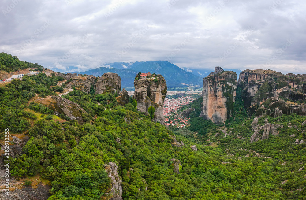 Panorama of Holy Trinity  Monastery. Beautiful scenic panoramic view, ancient traditional greek building on the top of huge stone pillar in Meteora,Thessaly, Greece, Europe on a cloudy day.