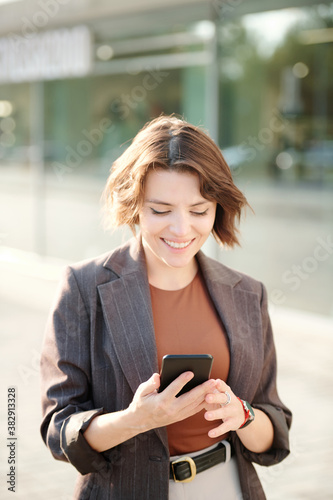 Cheerful young businesswoman in smart casualwear scrolling through contacts Free Download Cheerful young businesswoman in smart casualwear scrolling through contacts - GFXLoad
