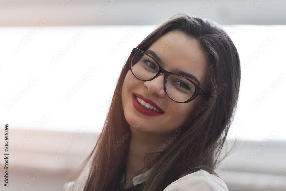 Young caucasian lady student looking at camera and smiling. Learning inside modern classroom. Education concept. Young caucasian lady student looking at camera and smiling. Learning inside modern classroom. Education concept.