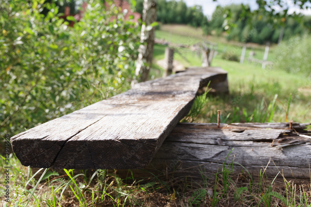 Wooden old bench in the garden in the village. Closeup
Wooden old bench in the garden in the village. Closeup