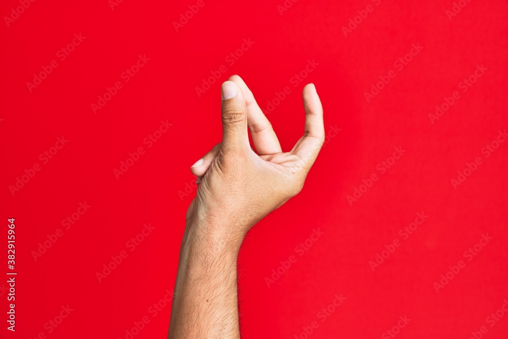 Arm of caucasian white young man over red isolated background snapping fingers for success, easy and click symbol gesture with hand Arm of caucasian white young man over red isolated background snapping fingers for success, easy and click symbol gesture with hand