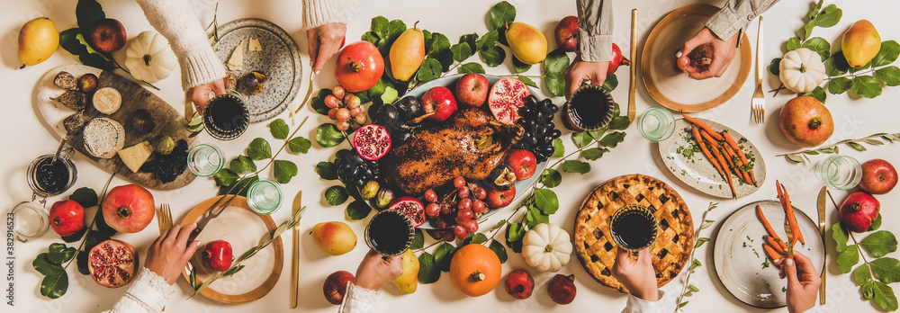 Autumn Thanksgiving, Friendsgiving, family party dinner. Flat-lay of peoples hands with wineglasses celebrating over table with roasted duck, vegetables, cheese board and apple pie, top view