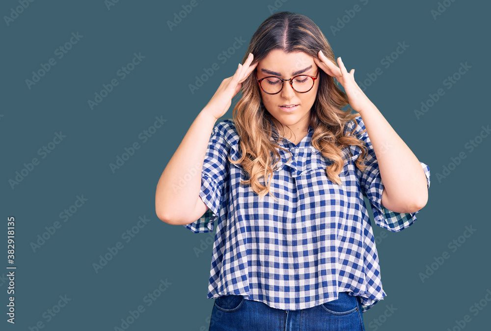 Young caucasian woman wearing casual clothes with hand on head for pain in head because stress. suffering migraine. Young caucasian woman wearing casual clothes with hand on head for pain in head because stress. suffering migraine.