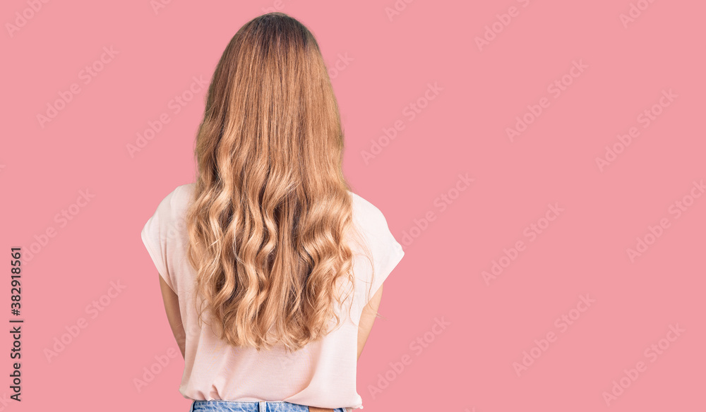 Naklejka premium Young beautiful caucasian woman with blond hair wearing casual clothes standing backwards looking away with crossed arms