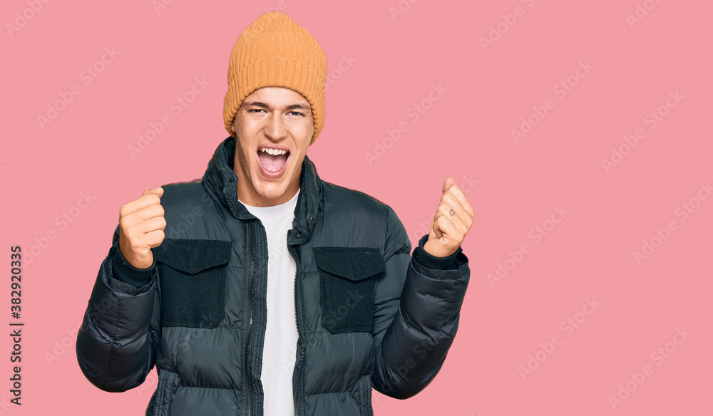 Handsome caucasian man wearing snow wear screaming proud, celebrating victory and success very excited with raised arms Handsome caucasian man wearing snow wear screaming proud, celebrating victory and success very excited with raised arms