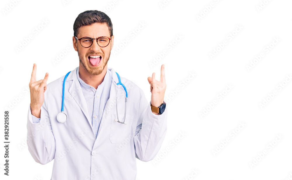 Handsome young man with bear wearing doctor uniform shouting with crazy expression doing rock symbol with hands up. music star. heavy concept. Handsome young man with bear wearing doctor uniform shouting with crazy expression doing rock symbol with hands up. music star. heavy concept.