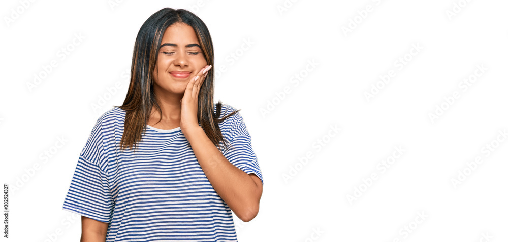 Young latin girl wearing casual clothes touching mouth with hand with painful expression because of toothache or dental illness on teeth. dentist