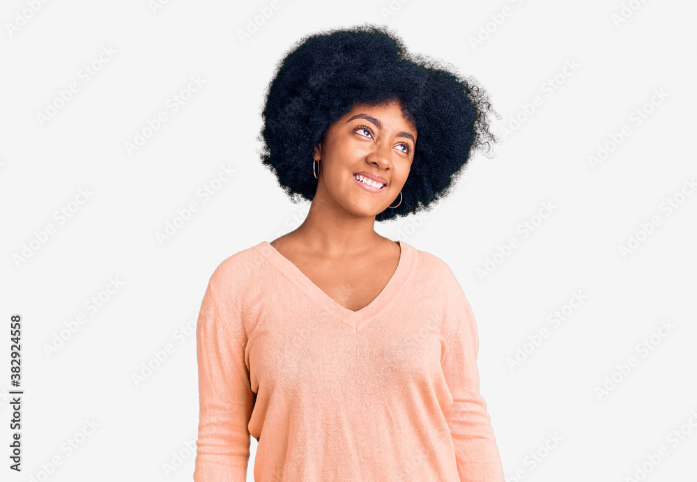 Young african american girl wearing casual clothes looking away to side with smile on face, natural expression. laughing confident. Young african american girl wearing casual clothes looking away to side with smile on face, natural expression. laughing confident.