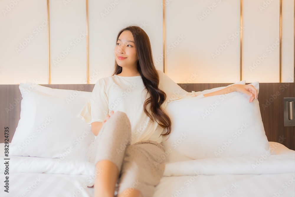 Portrait beautiful young asian woman smile relax on bed in bedroom interior Portrait beautiful young asian woman smile relax on bed in bedroom interior