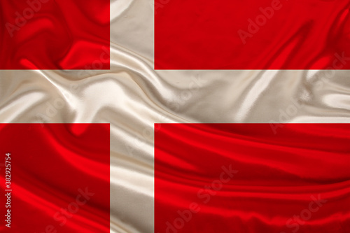 photo of the national flag of Denmark on a luxurious texture of satin, silk with waves, folds and highlights, close-up, copy space, concept of travel, economy and state policy, illustration