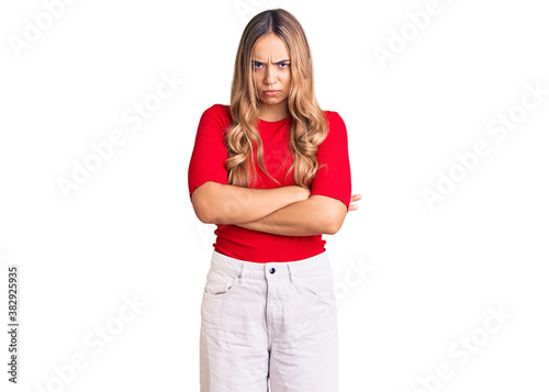 Young beautiful blonde woman wearing casual clothes skeptic and nervous, disapproving expression on face with crossed arms. negative person.