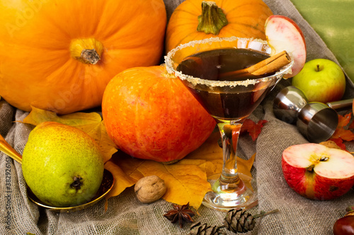 Autumn fall Halloween Thanksgiving season special martini cocktail. A photo composition with maple leaves, apples and pumpkin. For banner, cards or autumn bar special ads