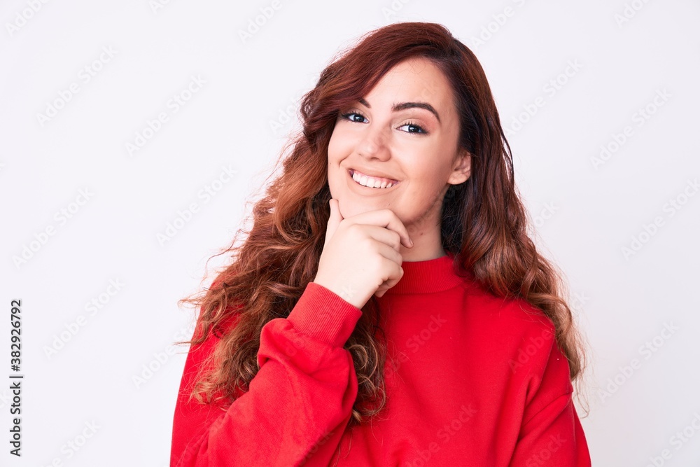 Young beautiful woman wearing casual clothes looking confident at the camera smiling with crossed arms and hand raised on chin. thinking positive. Young beautiful woman wearing casual clothes looking confident at the camera smiling with crossed arms and hand raised on chin. thinking positive.