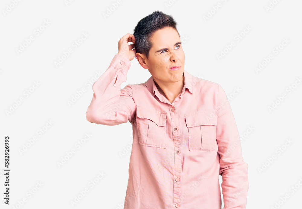 Young woman with short hair wearing casual clothes confuse and wondering about question. uncertain with doubt, thinking with hand on head. pensive concept. Young woman with short hair wearing casual clothes confuse and wondering about question. uncertain with doubt, thinking with hand on head. pensive concept.
