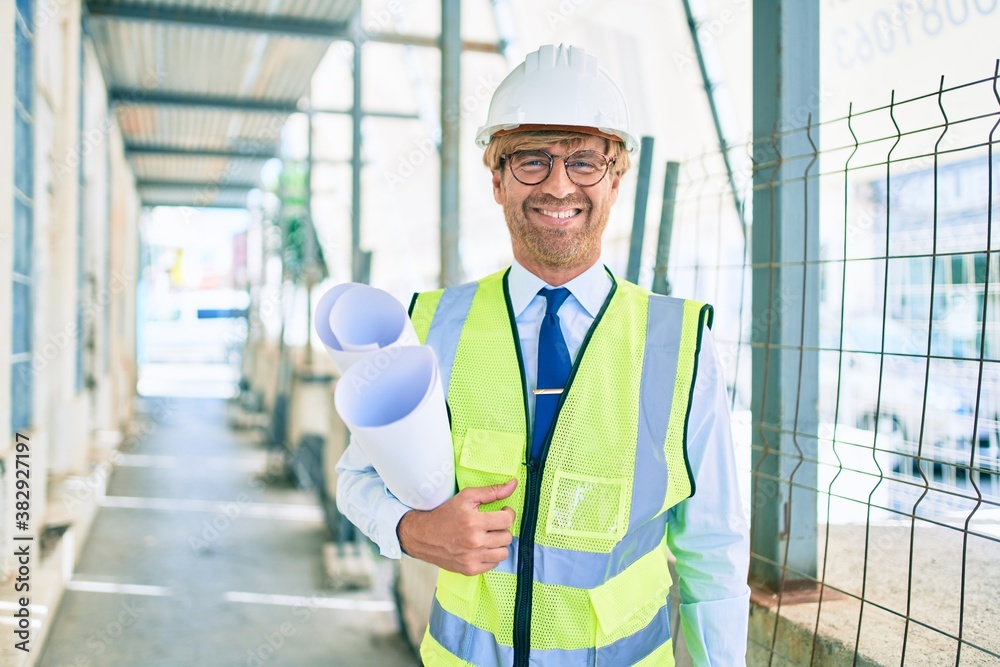 Business architect man wearing hardhat standing outdoors of a building project wearing reflective vest Business architect man wearing hardhat standing outdoors of a building project wearing reflective vest