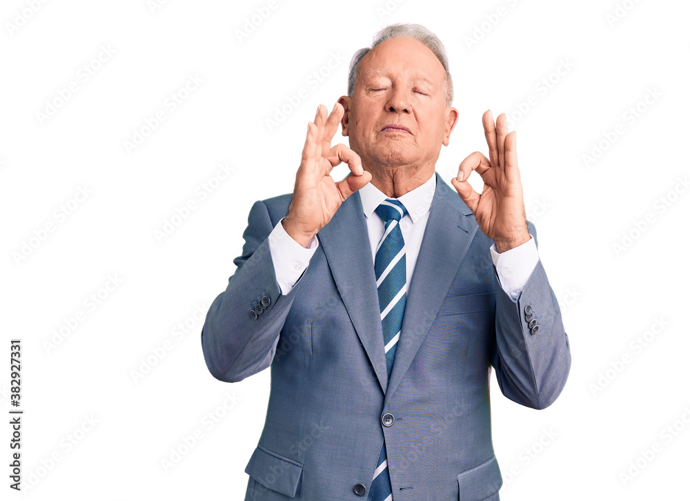 Senior handsome grey-haired man wearing elegant suit relax and smiling with eyes closed doing meditation gesture with fingers. yoga concept. Senior handsome grey-haired man wearing elegant suit relax and smiling with eyes closed doing meditation gesture with fingers. yoga concept.