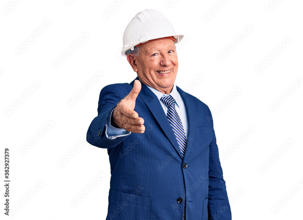Senior handsome grey-haired man wearing suit and architect hardhat smiling friendly offering handshake as greeting and welcoming. successful business. Senior handsome grey-haired man wearing suit and architect hardhat smiling friendly offering handshake as greeting and welcoming. successful business.