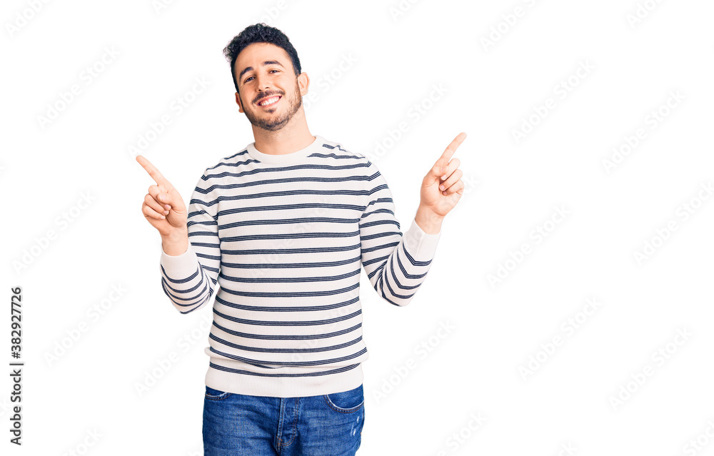 Young hispanic man wearing casual clothes smiling confident pointing with fingers to different directions. copy space for advertisement Young hispanic man wearing casual clothes smiling confident pointing with fingers to different directions. copy space for advertisement