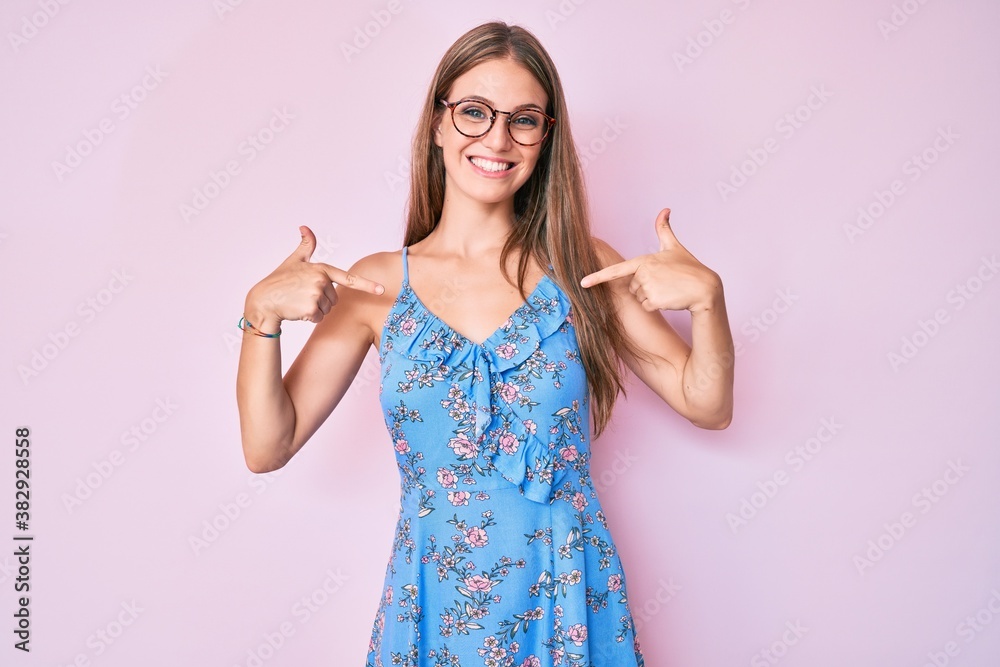 Young blonde girl wearing casual clothes and glasses looking confident with smile on face, pointing oneself with fingers proud and happy. Young blonde girl wearing casual clothes and glasses looking confident with smile on face, pointing oneself with fingers proud and happy.