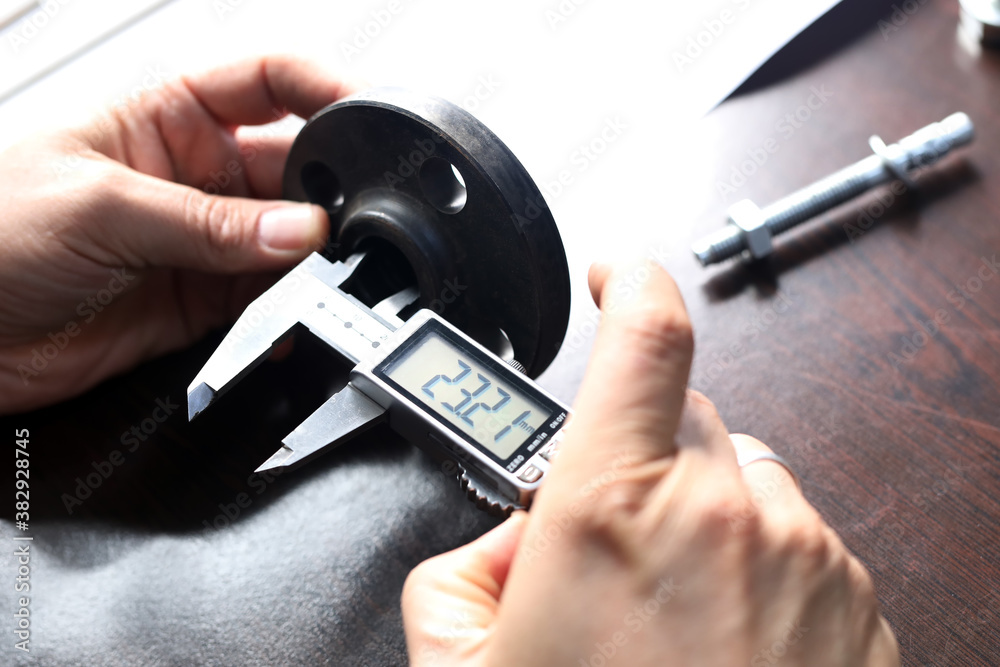 The worker is measuring to inner diameter of flange with vernier caliper gauge. Vernier calipers