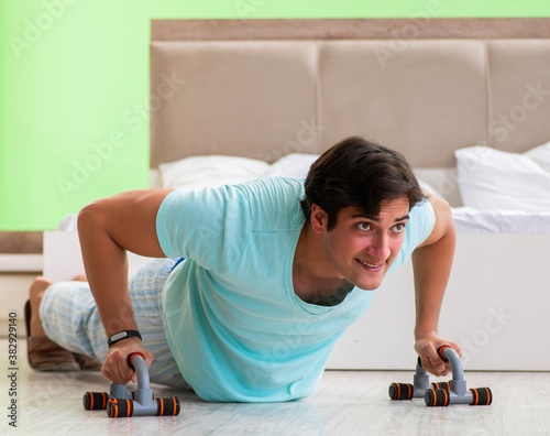 Young man in pajamas doing morning exercises